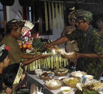 
					Prajuru Desa Adat Sepang memotong nasi tumpeng upacara sebagai tanda dimulainya tradisi tegak gede untuk pengesahan pernikahan kedua mempelai. (balisaja.com/I Made Sujaya)