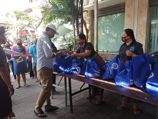 
					Nasabah krama tamiu mengambil hadiah daging babi, beras, dan kupon belanja di halaman samping kantor LPD Kedonganan, Senin (14/9).